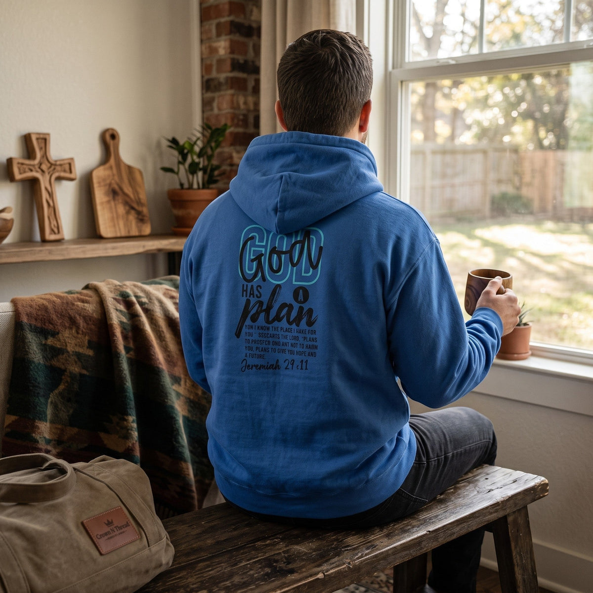 Crown N Thread blue pullover hoodie with God Has A Plan graphic and Jeremiah 29:11 verse on the back, worn by a man.
