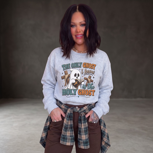 Woman wearing a Crown N Thread grey crewneck sweatshirt with a cute ghost graphic and faith-based text