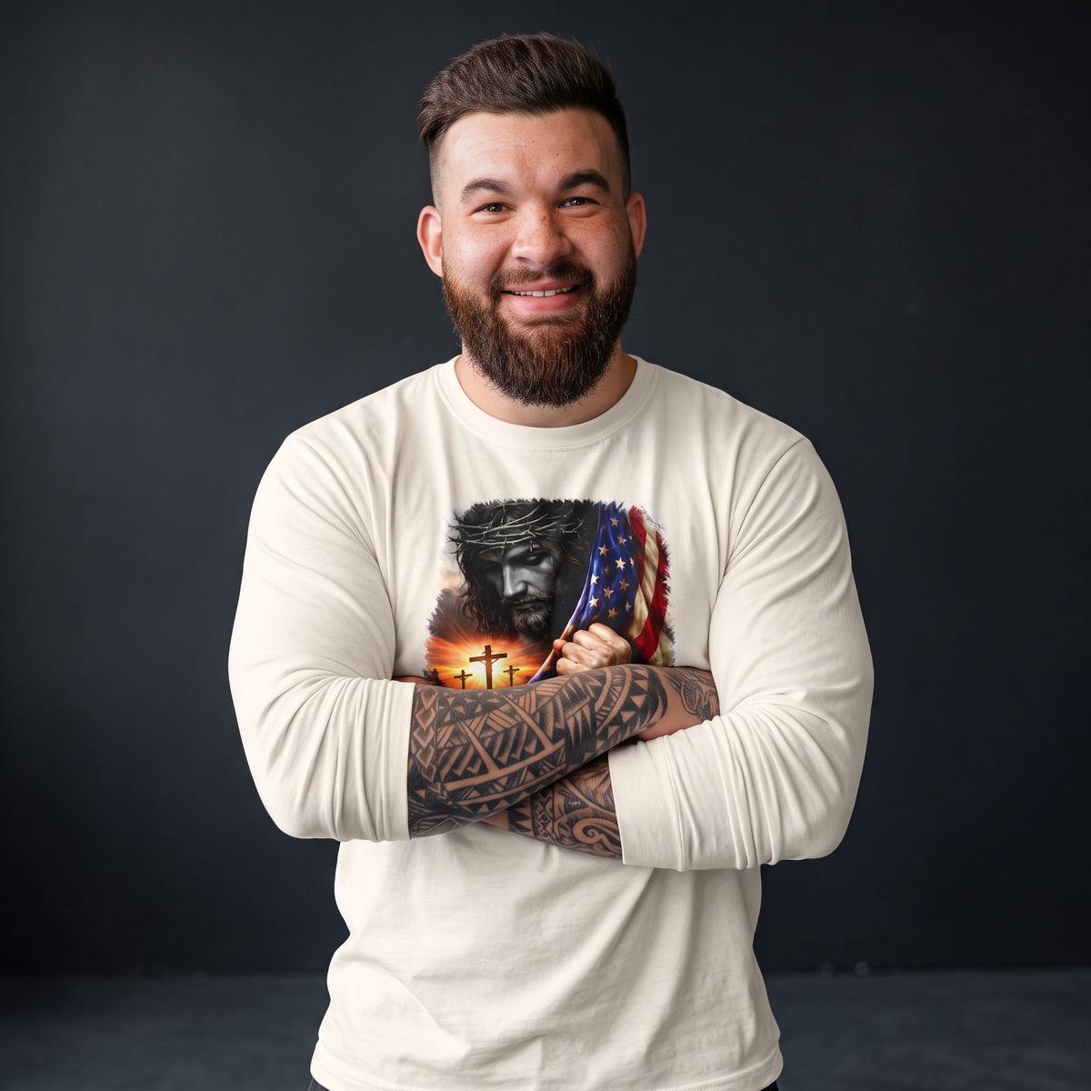 Crown N Thread cream long sleeve tee with Jesus and American flag graphic worn by a smiling tattooed man