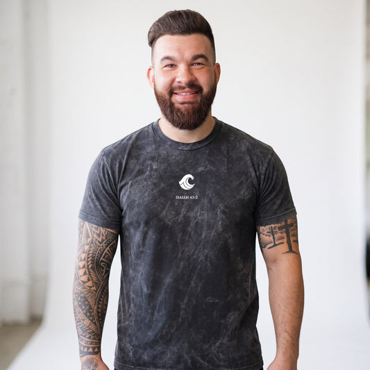 A man wearing a Crown N Thread mineral-washed black cotton crewneck t-shirt with a white whale and Isaiah 43:2 print.