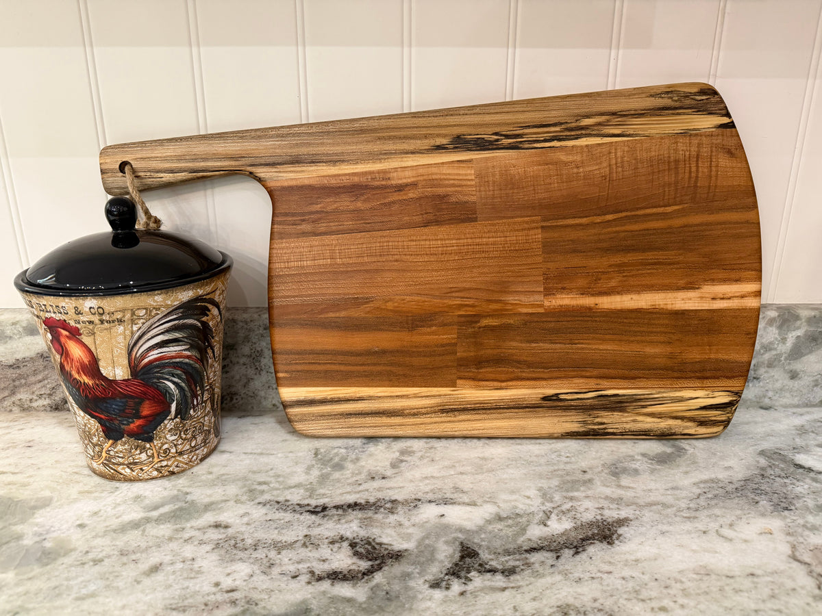 Crown N Thread handmade oiled wood charcuterie board with natural grain patterns resting on a kitchen counter